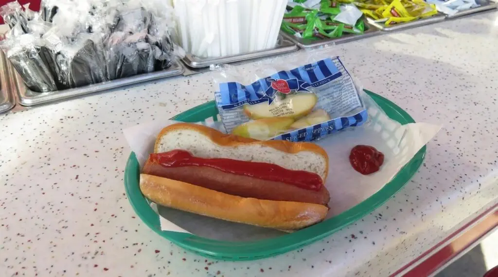 Gluten free hotdog at Disneyland with a side of sliced apples