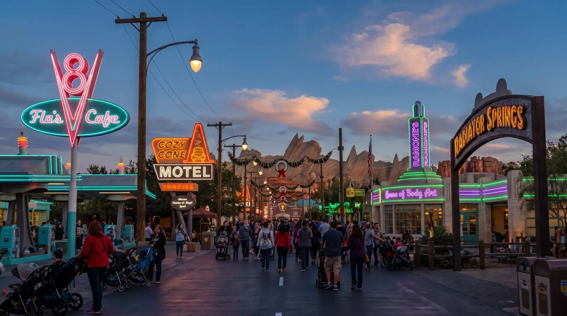 Neon Main Street in Cars Land at Disney California Adventure at dusk with Flo’s V8 Cafe and Cozy Cone Motel signs lit