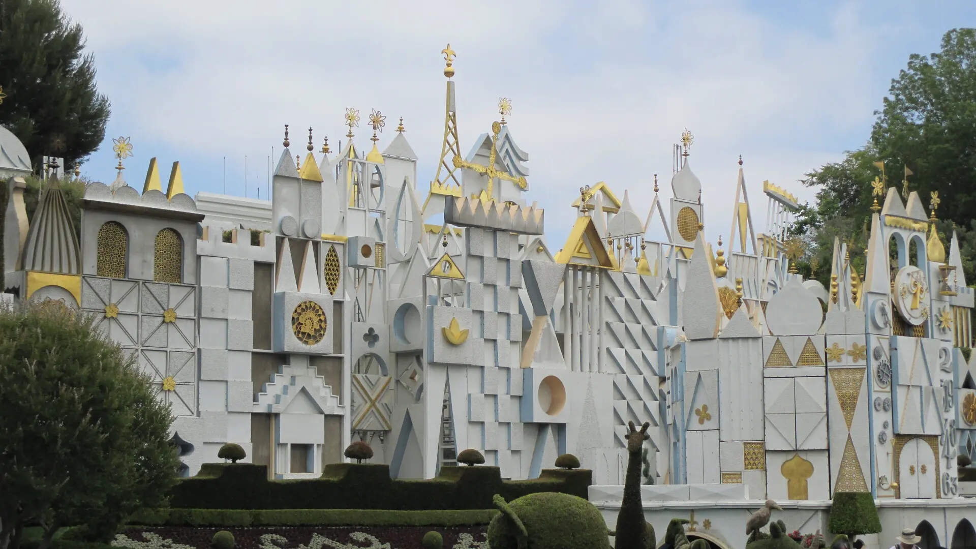 Angled daytime photo of the it's a small world facade and clock tower at Disneyland Fantasyland