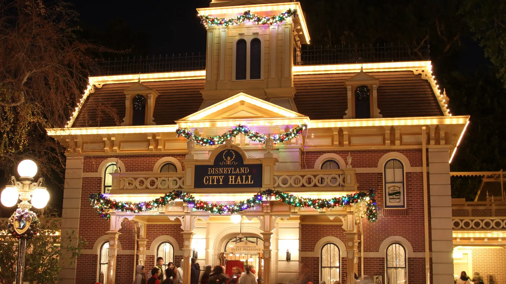 Disneyland Main Street City Hall decorated for the holidays with Christmas trees and garland