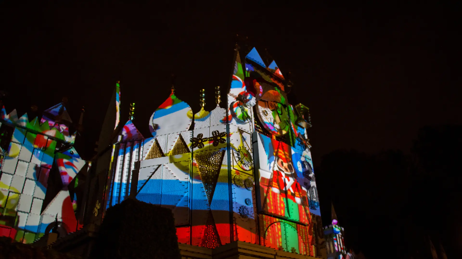 Nighttime holiday projection mapping on the it's a small world facade at Disneyland with toy soldier graphics