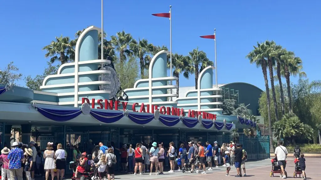 Crowds outside the Disney California Adventure Park entrance gates on a sunny day